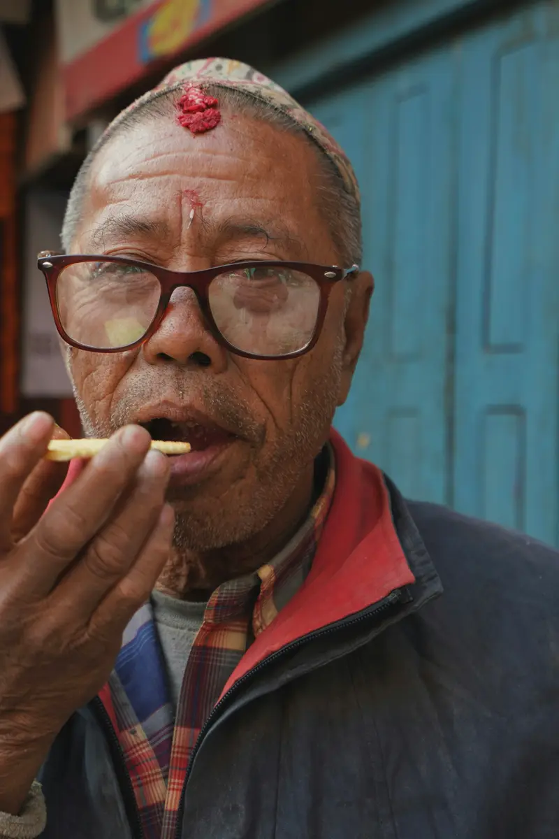Older man wearing dark-rimmed glasses
